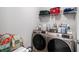 Functional laundry room equipped with a washer, dryer, shelving, and storage containers at 400 Paulownia Cir, Mcdonough, GA 30253