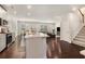 Open-concept living space with a kitchen island, dining area, living room, and staircase at 400 Paulownia Cir, Mcdonough, GA 30253