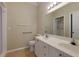 Bright bathroom featuring double sinks, large mirror, and accessible grab bars for convenience at 8020 Woodland Ln, Alpharetta, GA 30009