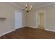 Chandelier-lit dining room featuring dark hardwood flooring and neutral wall colors at 8020 Woodland Ln, Alpharetta, GA 30009