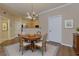 Cozy dining area with a round table, elegant chandelier, and hardwood floors at 8020 Woodland Ln, Alpharetta, GA 30009