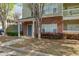 Inviting brick entrance of townhouse with manicured garden and covered entry at 8020 Woodland Ln, Alpharetta, GA 30009