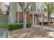 Inviting brick entrance of townhouse with manicured garden and covered entry at 8020 Woodland Ln, Alpharetta, GA 30009
