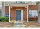 Charming brick front entrance with a gray door, manicured shrubs, and a welcoming mat for a personal touch at 8020 Woodland Ln, Alpharetta, GA 30009