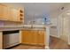 Modern kitchen with stainless steel dishwasher and wood cabinets at 8020 Woodland Ln, Alpharetta, GA 30009