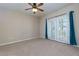 Spacious main bedroom featuring carpet floors, natural light, and bright white walls at 8020 Woodland Ln, Alpharetta, GA 30009