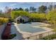 A community pool is closed for the season, surrounded by a lush landscape with trees and decorative plants at 8020 Woodland Ln, Alpharetta, GA 30009