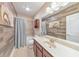 Bathroom with a single sink vanity, shower-tub combo, and wood-look accent wall at 1438 Kings Park Nw Dr, Kennesaw, GA 30152