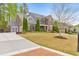 Beautifully landscaped home with a three-car garage, manicured lawn, and welcoming front entrance at 1438 Kings Park Nw Dr, Kennesaw, GA 30152