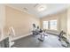 Bright home gym featuring exercise bike, workout bench, dumbbells, and large windows for natural light at 1438 Kings Park Nw Dr, Kennesaw, GA 30152