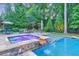 Backyard with a luxurious pool, hot tub with waterfall feature, and lush landscaping at 1438 Kings Park Nw Dr, Kennesaw, GA 30152