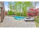 A stunning swimming pool with a stone paver deck is surrounded by lush landscaping at 1438 Kings Park Nw Dr, Kennesaw, GA 30152