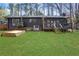 Large backyard with well-maintained lawn, a small deck with stairs, and a black-painted exterior at 3650 Dogwood Farm Rd, Decatur, GA 30034