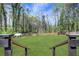 Large, grassy backyard with tall trees and a wooden fence at 3650 Dogwood Farm Rd, Decatur, GA 30034