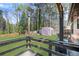 A spacious backyard featuring a wooden deck, lush green lawn, greenhouse, and an array of trees at 3650 Dogwood Farm Rd, Decatur, GA 30034