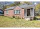 A cozy brick home showcasing a screened front porch, complemented by lush lawn at 854 Slaton St, Forest Park, GA 30297