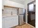 Bright kitchen features white cabinets, mosaic tile backsplash, stainless steel appliances, and tile flooring at 1780 John Calvin Ave, Atlanta, GA 30337