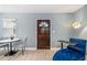 Cozy living room area with dark wood door and modern blue chaise lounge at 1780 John Calvin Ave, Atlanta, GA 30337