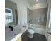 Modern bathroom boasts gray tiled shower over tub with black fixtures, sleek sink and a window offering natural light at 2155 Suncrest Point, Marietta, GA 30064