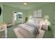 Charming bedroom features a bright window and matching nightstands, decorated with a clean, light-green palette at 2155 Suncrest Point, Marietta, GA 30064