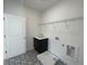 Functional laundry room with a utility sink, storage options, and tile flooring at 2155 Suncrest Point, Marietta, GA 30064
