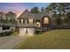 Inviting two-story home with brick and vinyl siding, a two-car garage, and a cozy front porch at dusk at 248 Christian Circle, Carrollton, GA 30116