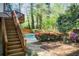 Inviting backyard with stairs leading to a pool surrounded by lush landscaping and fencing at 4983 Odins Way, Marietta, GA 30068