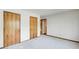 Bedroom showcasing neutral walls and flooring, two wooden closet doors, and minimalist design at 4983 Odins Way, Marietta, GA 30068