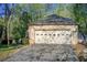 Attached two-car garage with decorative windows, a large driveway, and tidy landscaping at 4983 Odins Way, Marietta, GA 30068