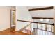 Hallway with hardwood floors, white banister and railing, leading to a sunlit room with skylights at 4983 Odins Way, Marietta, GA 30068