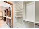 Spacious walk-in closet with custom shelving and dark wood cabinets in adjacent bathroom at 4983 Odins Way, Marietta, GA 30068