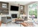 The well-lit living room features a fireplace, built-in shelves, refined furnishings, and a view of the backyard at 730 Denmead Se Ml, Marietta, GA 30067