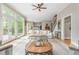 Bright living room features a ceiling fan, hardwood floors, and oversized windows with views of the backyard at 730 Denmead Se Ml, Marietta, GA 30067
