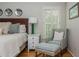 Cozy main bedroom with a sitting area, side table, hardwood floors, and bright windows at 730 Denmead Se Ml, Marietta, GA 30067
