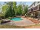 Backyard pool area with stone patio, mature trees, and landscaped yard at 730 Denmead Se Ml, Marietta, GA 30067