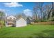 View of spacious backyard with green lawn and detached garage, perfect for outdoor activities at 3055 Alston Dr, Decatur, GA 30032