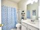 A bathroom with a toilet, sink, cabinet and a shower with a blue shower curtain at 4103 Christacy Way, Marietta, GA 30066