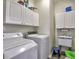 A bright laundry room with white cabinets, washing machine, dryer, and utility sink at 4103 Christacy Way, Marietta, GA 30066