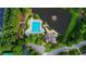 Aerial view of a neighborhood swimming pool and playground surrounded by trees and a small lake at 12350 Edenwilde Dr, Roswell, GA 30075