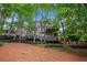 Backyard view featuring a tiered deck and patio with wooded surroundings at 12350 Edenwilde Dr, Roswell, GA 30075