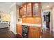 Elegant bar area with custom cabinets, granite countertop, and wine fridge at 12350 Edenwilde Dr, Roswell, GA 30075