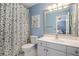 Bathroom features a floral shower curtain, white vanity, and a bright mirror at 12350 Edenwilde Dr, Roswell, GA 30075
