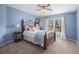 Cozy bedroom featuring light blue walls, carpet, and a large window for natural light at 12350 Edenwilde Dr, Roswell, GA 30075