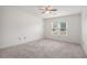 Bright empty bedroom with carpet, ceiling fan and one window offering plenty of natural light at 12350 Edenwilde Dr, Roswell, GA 30075