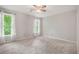 Bright empty bedroom with carpet, ceiling fan and two windows offering plenty of natural light at 12350 Edenwilde Dr, Roswell, GA 30075
