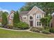 Stately two-story home with lush landscaping and a welcoming walkway at 12350 Edenwilde Dr, Roswell, GA 30075