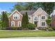 Charming two-story home featuring a well-manicured lawn and beautiful landscaping at 12350 Edenwilde Dr, Roswell, GA 30075