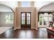 Grand foyer featuring dark wood floors, an elegant double door entrance, and arched doorways at 12350 Edenwilde Dr, Roswell, GA 30075