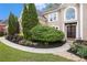 Close up front yard view showcasing beautiful flowerbed and walkway to a grand entrance at 12350 Edenwilde Dr, Roswell, GA 30075