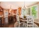 Open-concept kitchen and dining area with bright windows and custom wood cabinetry at 12350 Edenwilde Dr, Roswell, GA 30075